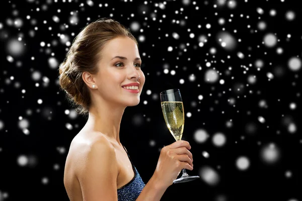 Sonriente mujer sosteniendo un vaso de vino espumoso —  Fotos de Stock