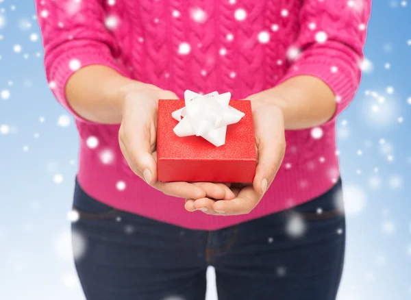 Close up of woman in pink sweater holding gift box — Stock Photo, Image