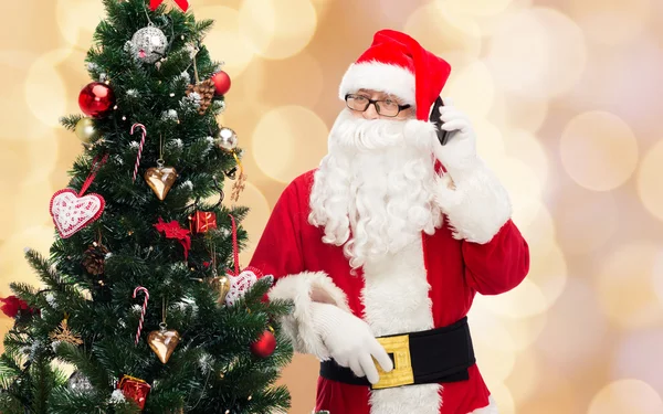 Санта-Клаус со смартфоном и елкой — стоковое фото