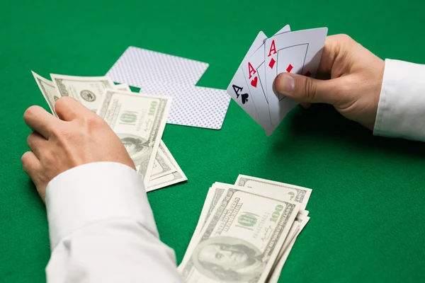 Pokerspeler met kaarten en geld bij casino — Stockfoto