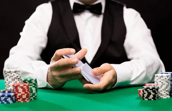Distribuidor Holdem con cartas de juego y fichas de casino — Foto de Stock