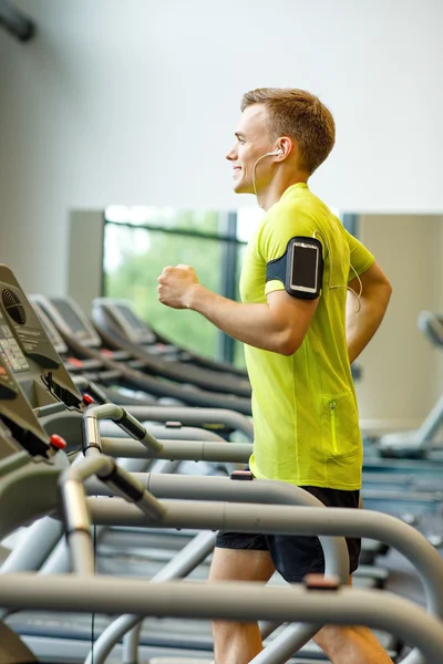 Glimlachende man uitoefenen op loopband in de sportschool — Stockfoto