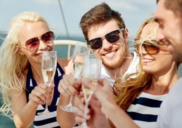 Amigos sonrientes con copas de champán en el yate —  Fotos de Stock