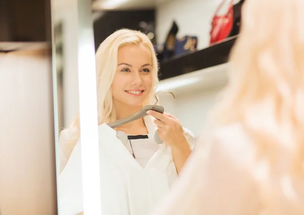 Feliz joven mujer elegir ropa en el centro comercial —  Fotos de Stock