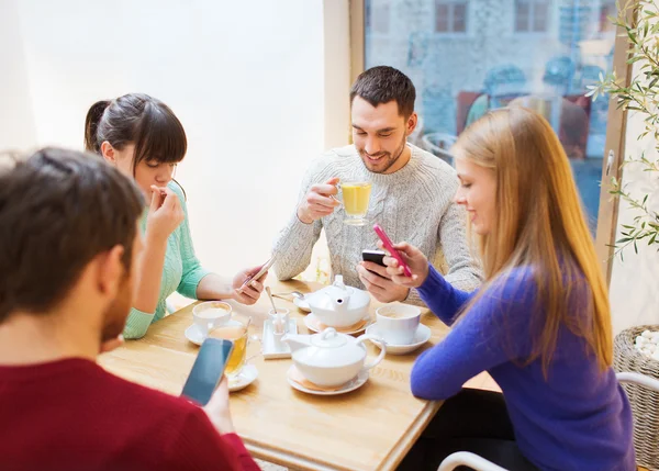 Gruppo di amici con smartphone che si incontrano al caffè — Foto Stock