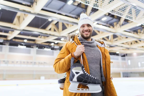 Gelukkig jonge man met ice-skates op de ijsbaan — Stockfoto