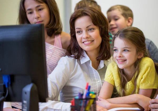 Group of kids with teacher and computer at school — Stock Photo, Image