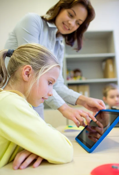 Menina com professor e tablet pc na escola — Fotografia de Stock