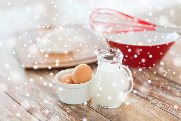 Close up of milk jug, eggs, whisk and flour — Stock Photo, Image