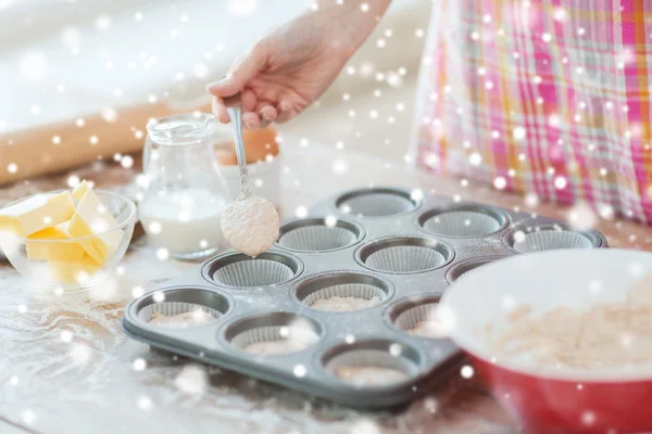 Close up of woman filling muffins molds with dough — Stock Photo, Image