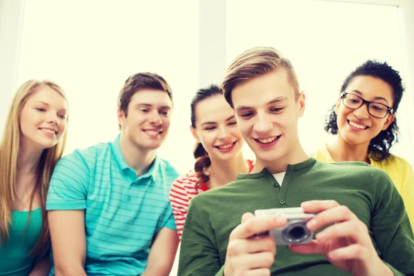 Studenti sorridenti con fotocamera digitale a scuola — Foto Stock