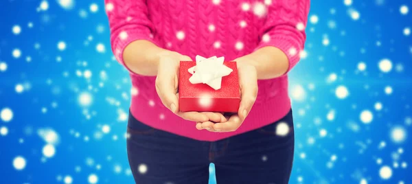 Primer plano de la mujer en suéter rosa celebración caja de regalo —  Fotos de Stock