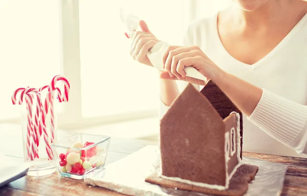 Primer plano de la mujer haciendo casas de pan de jengibre — Foto de Stock