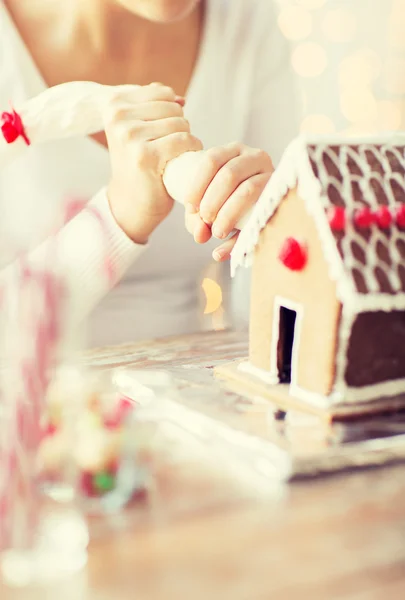 Close up of woman making gingerbread house at home — Stock Photo, Image