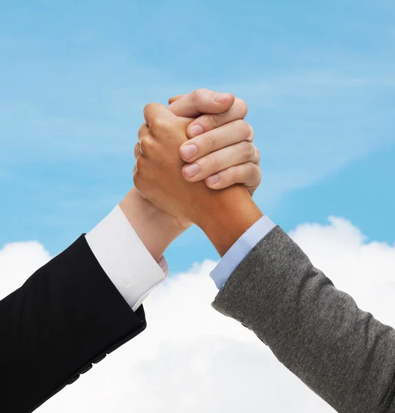 Close up of hands armwrestling over concrete wall — Stock Photo, Image