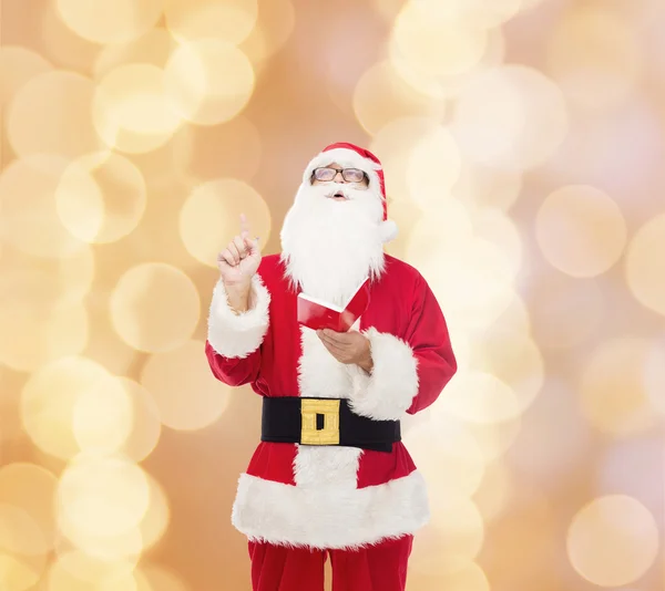 Man in kostuum van de kerstman met Kladblok — Stockfoto