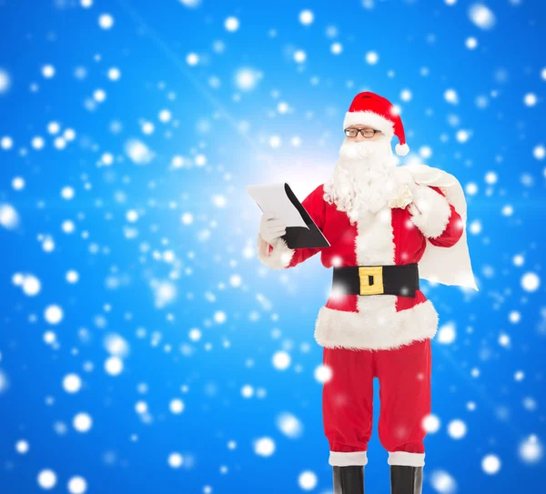 Uomo in costume di Babbo Natale con blocco note e borsa — Foto Stock