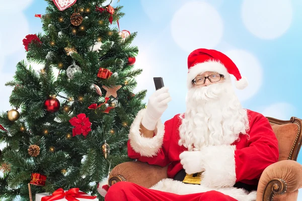 Santa Claus con smartphone y árbol de Navidad —  Fotos de Stock