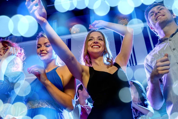 Smiling friends dancing in club — Stock Photo, Image