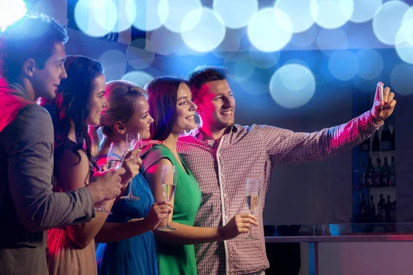 Friends with glasses and smartphone in club — Stock Photo, Image