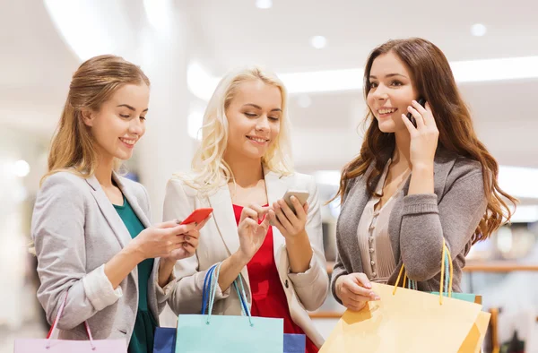 Donne felici con smartphone e shopping bag — Foto Stock