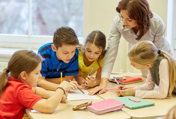Group of school kids writing test in classroom — Stock Photo, Image