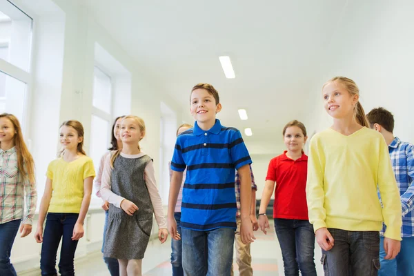 Groupe d'écoliers souriants marchant dans le couloir — Photo