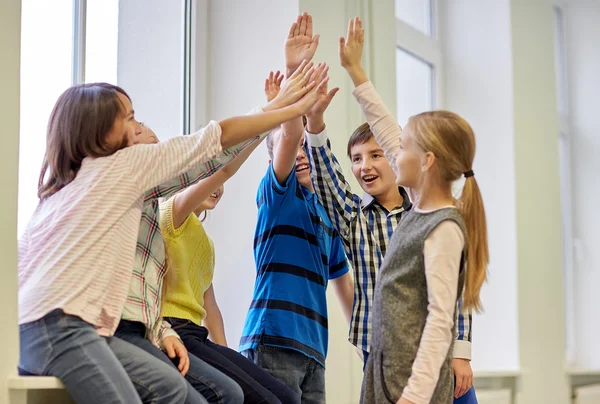 Gruppo di bambini sorridenti scuola fare alto cinque — Foto Stock