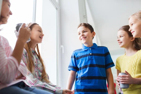 Group of school kids with soda cans in corridor — Stock Photo, Image