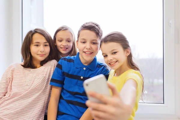 Grupp av skolbarnen tar selfie med smartphone — Stockfoto