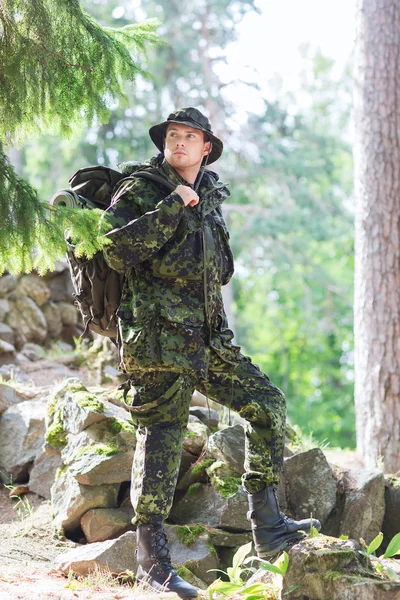 Young soldier with backpack in forest — Stock Photo, Image