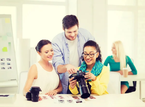 Equipo sonriente con cámara fotográfica trabajando en la oficina — Foto de Stock