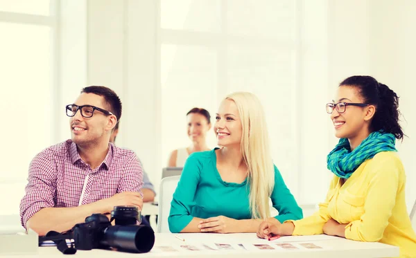 Equipo sonriente con cámara fotográfica trabajando en la oficina —  Fotos de Stock