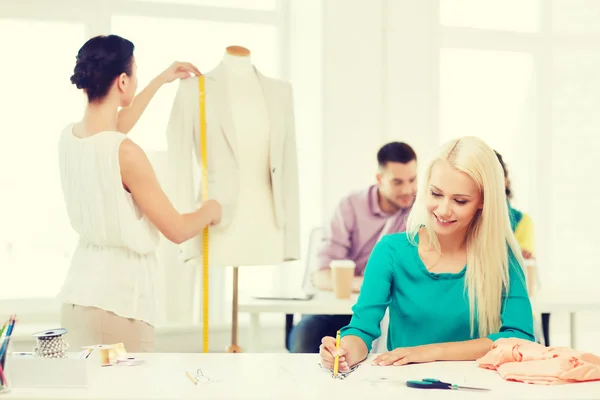 Diseñadores de moda sonrientes trabajando en la oficina — Foto de Stock