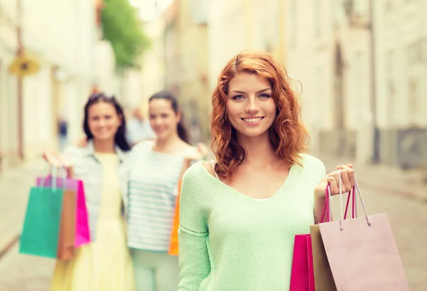 Lachende tienermeisjes met boodschappentassen op straat — Stockfoto