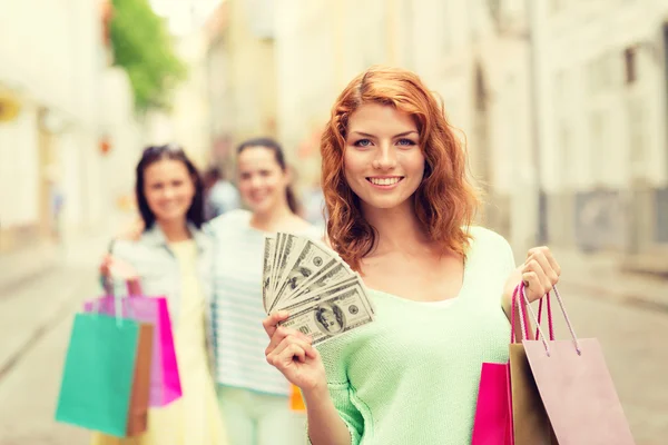 Smiling teenage girls with shopping bags on street — Stock Photo, Image