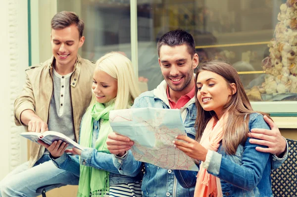 Grupo de amigos com guia e mapa explorando a cidade — Fotografia de Stock