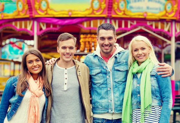 Grupo de amigos sorridentes no parque de diversões — Fotografia de Stock