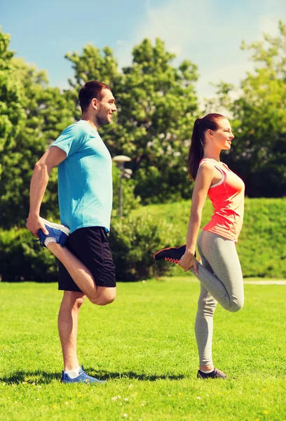 Smiling couple stretching outdoors — Stock Photo, Image