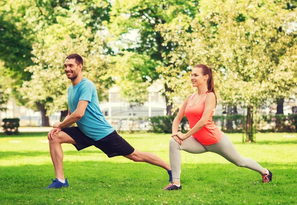 Sonriente pareja estirándose al aire libre — Foto de Stock