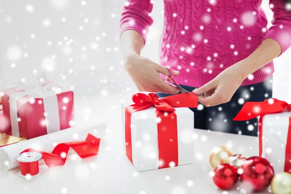 Zamknij się z kobietą, którą dekorowanie świątecznych prezentów — Zdjęcie stockowe