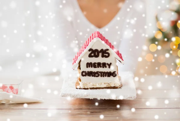 Close up of woman showing gingerbread house — Stock Photo, Image