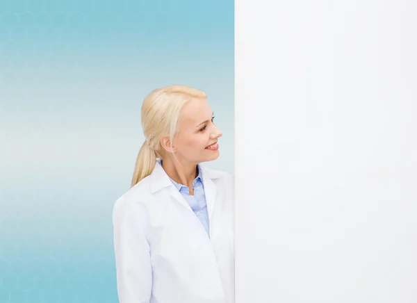 Médica sorridente com placa branca em branco — Fotografia de Stock