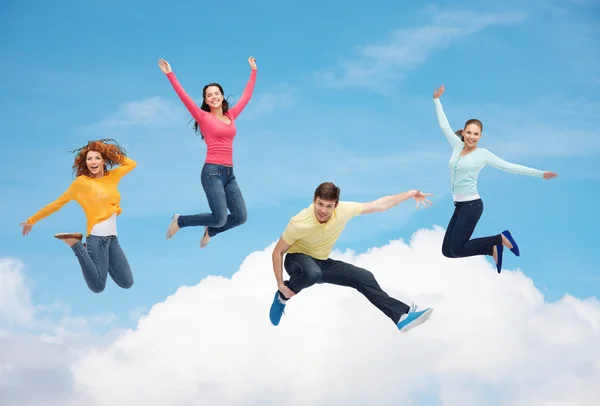 Grupo de adolescentes sonrientes saltando en el aire — Foto de Stock