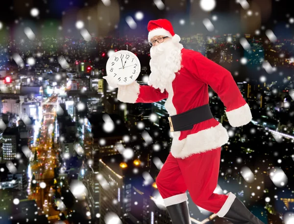 Man in costume of santa claus with clock — Stock Photo, Image