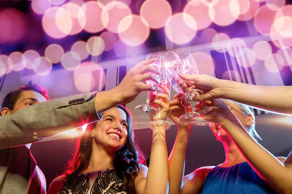 Amigos sonrientes con copas de champán en el club — Foto de Stock