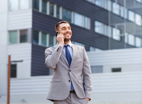 Uomo d'affari sorridente con smartphone all'aperto — Foto Stock