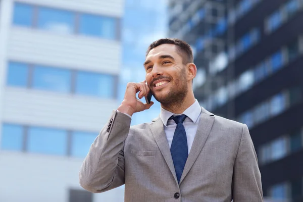 Uśmiechający się biznesmen z smartphone na zewnątrz — Zdjęcie stockowe