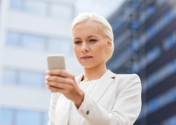 Femme d'affaires sérieuse avec smartphone en plein air — Photo