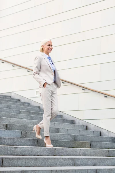 Jeune femme d'affaires souriante descendant les escaliers — Photo